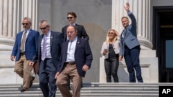 Republican Representative Marc Molinaro, right, waves next to Republican Representative Marjorie Taylor Greene as members of Congress leave the House for Memorial Day weekend, May 25, 2023, on Capitol Hill in Washington.