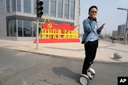 中国河北雄安街头一名男子路过一处口号宣传牌。（2023年4月1日）