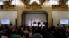 France's President Emmanuel Macron gives a speech next to International Olympic Committee (IOC) President Thomas Bach and others during a reception for international journalists accredited for the Paris 2024 Olympic Games, July 22, 2024. 