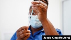 (FILE) A nurse prepares a dose of a coronavirus disease (COVID-19) vaccine.