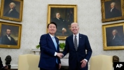 FILE - President Joe Biden shakes hands with South Korea's President Yoon Suk Yeol as they meet in the Oval Office of the White House, April 26, 2023, in Washington.
