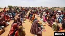 Sudanese refugees, who have fled the violence in their country, wait to receive food rations from World Food Program, near the border in Koufroun, Chad, May 9, 2023. 