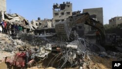 Palestinci obilaze uništenu zgradu u izraelskom napadu na Gazu (Foto: AP/Abed Khaled)
