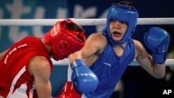 In this photo provided by the International Olympic Committee, Maksym Halinichev of Ukraine, right, competes against Abdumalik Khalokov of Uzbekistan during the Youth Olympic Games in Buenos Aires, Argentina, Oct. 18, 2018. 