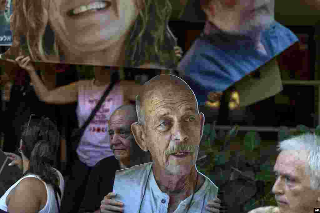 Relatives and supporters of Israeli hostages taken by Hamas in Gaza hold photos of their loved ones, including Haim Peri, center, during a protest calling for their return in Tel Aviv.