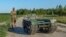 Andrii Denysenko, CEO of design and production bureau "UkrPrototyp," stands by Odyssey, an 800-kilogram ground drone prototype, at a corn field in northern Ukraine, June 28, 2024.
