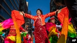 FILE - Revelers take part during the Chinese New Year 'The Dragon' parade in the Chinatown neighborhood of Manhattan, New York, Feb. 25, 2024.
