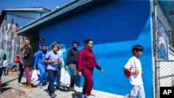 Satu keluarga migran asal Venezuela tiba di tempat penampungan yang dioperasikan oleh Gereja Sacred Heart di El Paso, Texas, pada 12 Mei 2023. (Foto: AP/Andres Leighton)