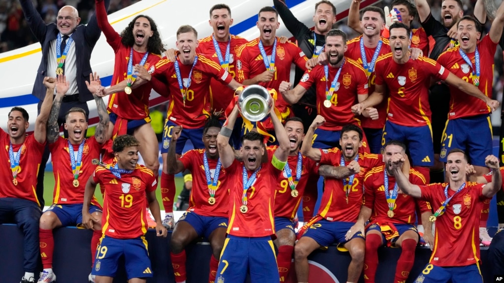 Spain's Alvaro Morata holds the trophy as he celebrates with his teammates after winning the final match between Spain and England at the Euro 2024 soccer championship in Berlin, Germany, July 14, 2024.