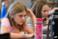 Olivia Laski, left, and Annabelle Harwood attempt to "Find the Bot" in Donnie Piercey's class at Stonewall Elementary in Lexington, Ky., Monday, Feb. 6, 2023.