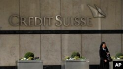 Seorang wanita berjalan melewati kantor pusat bank Credit Suisse di London, Kamis, 16 Maret 2023. (Foto: Frank Augstein/AP)