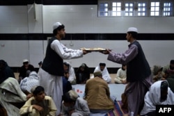 Muslim Afghanistan membagikan makanan di masjid saat berbuka puasa pada hari pertama bulan suci Ramadan di Kandahar, 11 Maret 2024. (Sanaullah SEIAM / AFP)
