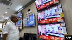 A man watching television waits for the release of exit polls published after voting concludes during its seventh and final phase amid India's general election, at an appliance store in Ajmer on June 1, 2024.