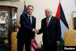 U.S. Secretary of State Antony Blinken shake hands with Palestinian President Mahmoud Abbas, in Amman, Jordan, Oct. 13, 2023.