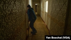 A former Bakhmut living in a shelter in Konstiantynivka, in the Donetsk Region of Ukraine, tries to open the door of the room that he calls home now, on April 11, 2023.