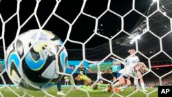 The ball hits the back of net as England's Lauren Hemp, right, scores against Colombia during the Women's World Cup quarterfinal soccer match between England and Colombia at the Sydney Football Stadium in Sydney, Australia, Aug. 12, 2023.