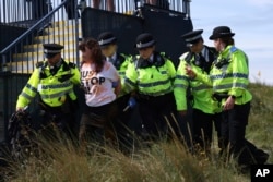 FILE - A protester is led away by police at the British Open at the Royal Liverpool Golf Club in Hoylake, England, July 21, 2023. (AP Photo/Peter Morrison, File)