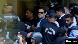 FILE - Security officers escort Pakistani former Prime Minister Imran Khan, center, as he appears in Islamabad High Court, in Islamabad, Pakistan, May 12, 2023.