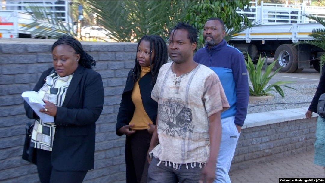 Human rights defenders Vusumuzi Moyo, Namatai Kwekweza, Samuel Gwenzi, and Robson Chere arrive at the Rotten Row Magistrates court in Harare with members of Zimbabwe republic police, Aug. 2, 2024.