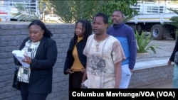 Human rights defenders Vusumuzi Moyo, Namatai Kwekweza, Samuel Gwenzi, and Robson Chere arrive at the Rotten Row Magistrates court in Harare with members of Zimbabwe republic police, Aug. 2, 2024.