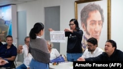 Seorang warga Venezuela menerima informasi tentang pencoblosan dalam pemilihan presiden di Kedutaan Venezuela di Panama city, Panama, Minggu, 28 Juli 2024. (Foto: Arnulfo Franco/AFP)