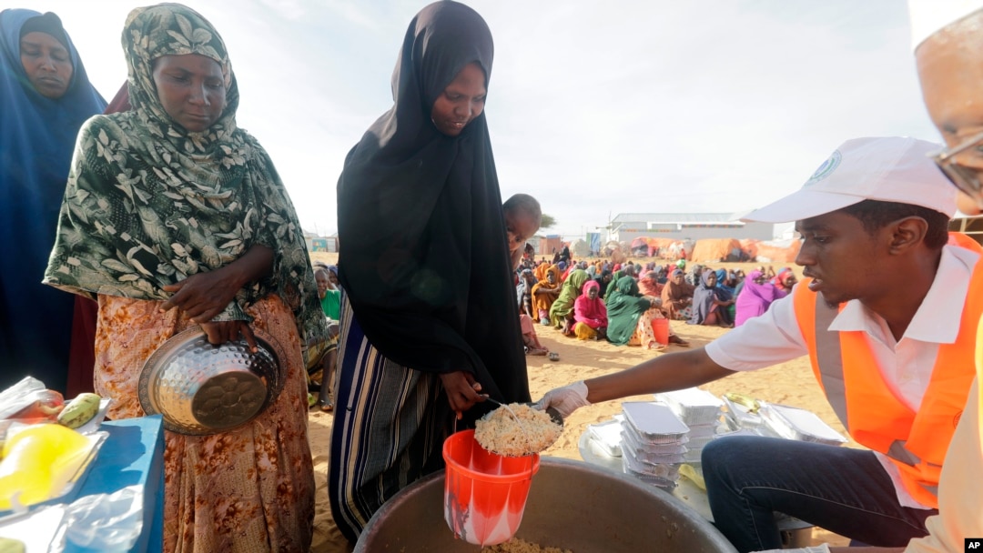 LSM setempat menyiapkan makanan berbuka puasa untuk orang-orang di kamp pengungsi di pinggiran Mogadishu, Somalia, Jumat, 24 Maret 2023. Bulan suci Ramadan tahun ini bertepatan dengan rekor kemarau terpanjang di Somalia. (AP/Farah Abdi Warsameh)