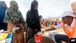 LSM setempat menyiapkan makanan berbuka puasa untuk orang-orang di kamp pengungsi di pinggiran Mogadishu, Somalia, Jumat, 24 Maret 2023. Bulan suci Ramadan tahun ini bertepatan dengan rekor kemarau terpanjang di Somalia. (AP/Farah Abdi Warsameh)