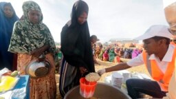 LSM setempat menyiapkan makanan berbuka puasa untuk orang-orang di kamp pengungsi di pinggiran Mogadishu, Somalia, Jumat, 24 Maret 2023. Bulan suci Ramadan tahun ini bertepatan dengan rekor kemarau terpanjang di Somalia. (AP/Farah Abdi Warsameh)