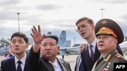 In this photograph distributed by the Russian Defense Ministry, North Korea's leader Kim Jong Un, second from left, and Russia's Defense Minister Sergei Shoigu, right, visit Knevichi aerodrome near Vladivostok, Russia, Sept. 16, 2023.