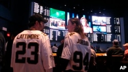 FILE - Football fans wait for kickoff in the sports betting lounge at the Ocean Casino Resort in Atlantic City, N.J., Sept. 9, 2018. (AP Photo/Wayne Parry, File)