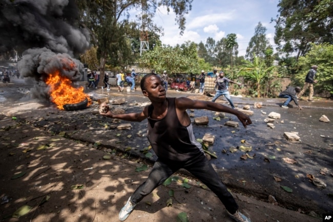 A protester throws rocks towards police in the Kibera slum of Nairobi, Kenya, March 20, 2023.