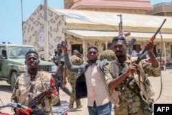 This picture taken on April 16, 2023, shows Sudanese army soldiers, loyal to army chief Abdel Fattah al-Burhan, posing for a picture at the Rapid Support Forces (RSF) base in the Red Sea city of Port Sudan.