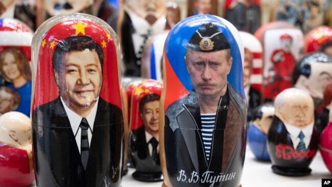 FILE - Russian matryoshka dolls with portraits of Chinese President Xi Jinping, left, and Russian President Vladimir Putin are displayed among others for sale at a souvenir shop in Moscow, on March 21, 2023.