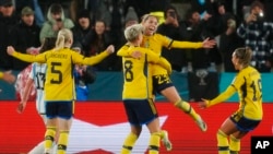 Sweden's Elin Rubensson, top, celebrates with teammates after scoring her side's second goal from the penalty spot during the Women's World Cup Group G soccer match between Argentina and Sweden in Hamilton, New Zealand, Aug. 2, 2023. 
