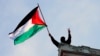 一名抗议人士在美国哥伦比亚大学汉密尔顿大厅的顶部挥舞一面巴勒斯坦旗帜。（2024年4月30日）