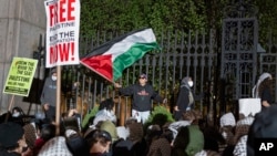 Pro-Palestianian protesters gather near a main gate at Columbia University in New York, April 30, 2024, just before New York City police officers cleared the area after a building was taken over by protesters earlier in the day.
