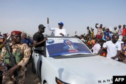 Succes Masra, leader of the Chadian opposition party Les Transformateurs (C), reacts while greeting some of his supporters from a car during the launch of his presidential campaign in N'Djamena, April 14, 2024.