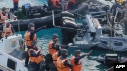 This frame grab from handout video taken on June 17, 2024 shows China coast guard personnel appearing to wield bladed weapons during an incident off Second Thomas Shoal. (Armed Forces of the Philippines - Public Affairs Office/ AFP) 