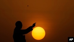 The sun sets behind a statue of Bhimrao Ramji Ambedkar, the chief architect of the Indian Constitution, in Hyderabad, India.
