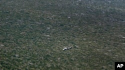 FILE - A Kenyan army helicopter flies over forest near Kismayo, Somalia, on Oct. 2, 2012, where allied African troops were fighting al-Shabab Islamist rebels. Al-Shabab limits tree cutting in areas of Somalia it controls, in part to hide it from aerial attack.