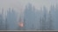 FILE - Flames and smoke rise from a wildfire visible from a highway in Jasper, Alberta, Canada, July 23, 2024, in this screen grab from a social media video. (Donald Schroll via Reuters)