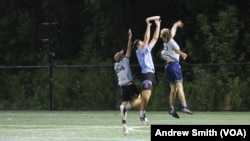 Jayden Feagans of the University of North Carolina's Darkside ultimate frisbee team makes a catch between two members of the Carolina Flyers in Chapel Hill, North Carolina, Thursday April 13, 2023 (VOA Photo/Andrew Smith)