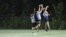 Jayden Feagans of the University of North Carolina's Darkside ultimate frisbee team makes a catch between two members of the Carolina Flyers in Chapel Hill, North Carolina, Thursday April 13, 2023 (VOA Photo/Andrew Smith)