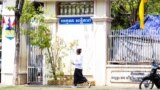 A student walks pass a sign "Thank You, Peace" in front of the Chatomuk Secondary School in Phnom Penh, on Monday, March 20, 2023. (Ten Soksreinith/VOA Khmer)