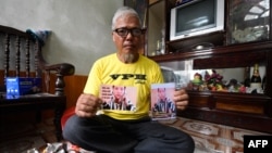 FILE - This picture taken on April 24, 2018 shows Nguyen Truong Chinh displaying portraits of his son and death row inmate Nguyen Van Chuong during an interview with AFP at his home in Hai Duong, Vietnam. 