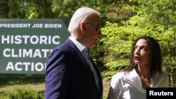 Foto ilustrasi yang menunjukkan Presiden AS Joe Biden dan anggota Kongres AS Alexandria Ocasio-Cortez berjalan bersama dalam sebuah acara memperingati Hari Bumi di Prince William Forest Park in Triangle, Virginia, AS, pada 22 April 2024. (Foto: Reuters/Kevin Lamarque)