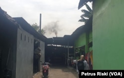 Asap hitam keluar dari salah satu cerobong asap pabrik tahu di Desa Tropodo, Krian, Sidoarjo (foto Petrus Riski-VOA)