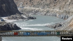 FILE - View of a bridge with China and Pakitan's flag over the River Indus, at the site of Dasu Dam or Dasu Hydropower Project, in Kohistan district Kyber Pakhtunkhwa province, near Dasu, Pakistan, Oct. 6, 2023. 