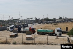 FILE - Trucks carrying aid wait on the Palestinian side of the border with Egypt, as the conflict between Israel and Hamas continues, in Rafah in the southern Gaza Strip, Oct. 21, 2023.