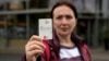 Erdina Laca, pencari suaka berusia 45 tahun, menunjukkan kartu pembayaran tunjangan khusus miliknya di depan toko kelontong, di kota Eichsfeld, Jerman.